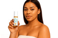 Woman holding a skincare product bottle with a white background